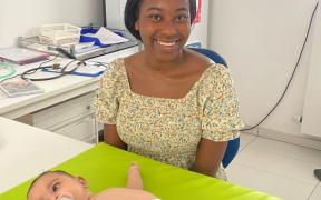 Judith in een consultatiebureau, voor haar ligt een baby op tafel