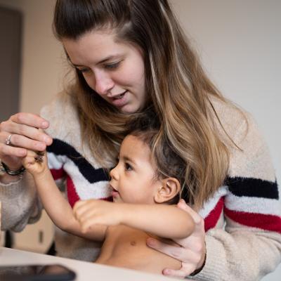 verpleegkundige Kind en Gezin tijdens consult met peuter op de schoot
