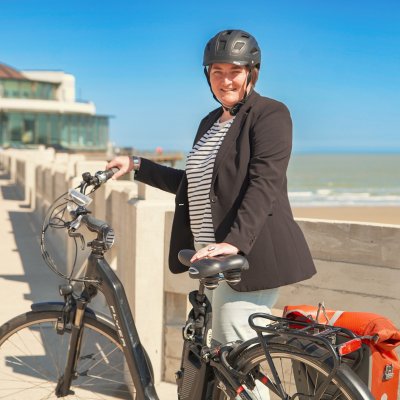 Verpleegkundige Geertrui met haar fiets op de dijk aan het strand