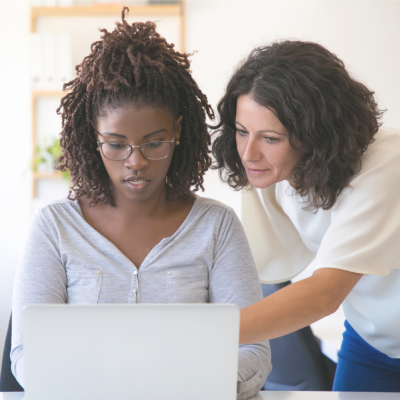 twee vrouwelijke collega's aan computer.