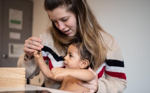 verpleegkundige Kind en Gezin tijdens consult met peuter op de schoot