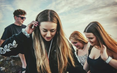 Meisjes en jongen dansen bij schemeravond.