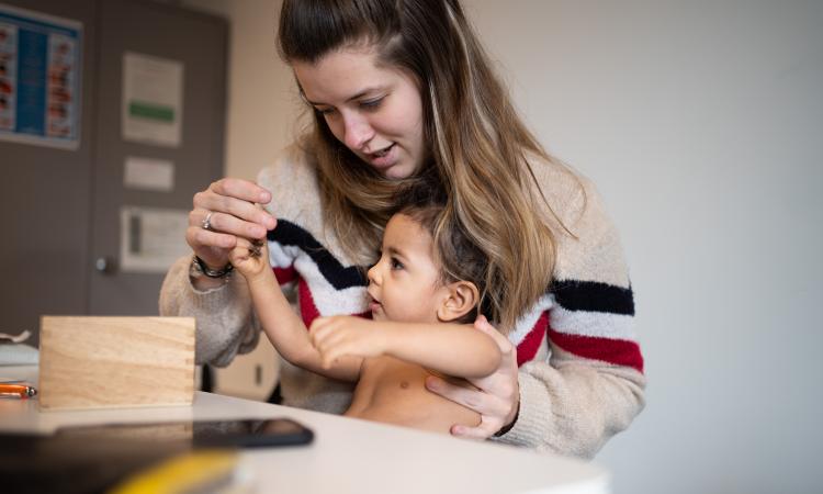 verpleegkundige tijdens consult met peuter op de schoot