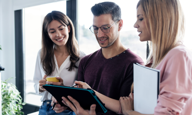 Groep collega's staat bij elkaar en is aan het overleggen