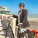 Verpleegkundige Geertrui met haar fiets op de dijk aan het strand