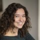 Laura Vanderveken van team Communicatie kijkt lachend in lens