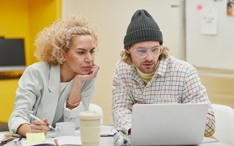2-collega-s-kijken-op-laptop-en-noteren-zaken