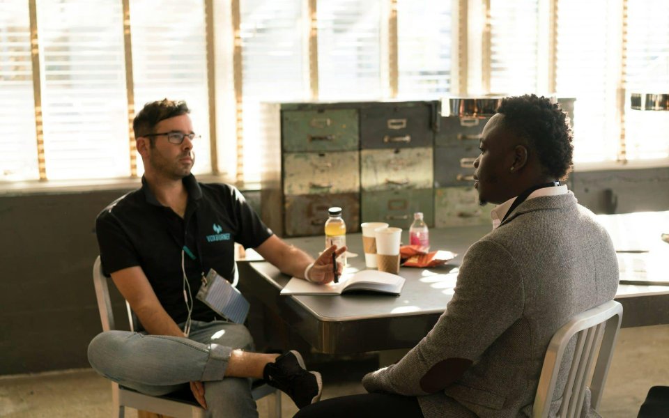 2-mannen-aan-bureau-in-gesprek.
