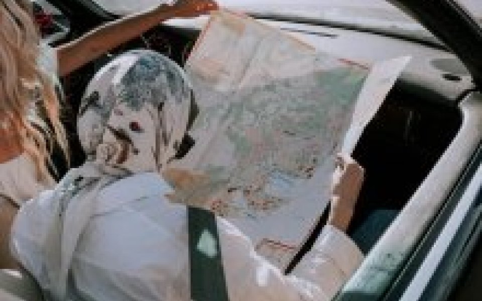 2 vrouwen in de auto kijken naar een papieren landkaart