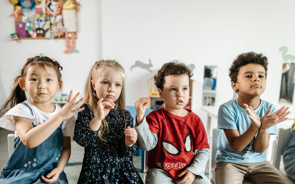 4-kleuters-in-een-klas-maken-handgebaren