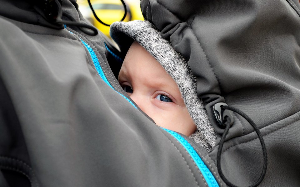 Nieuwsbericht Opgroeien Baby geborgen in draagzak op de buik