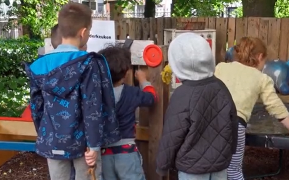 Kinderen spelen samen in de modderkeuken van de samenspeeltuin in Antwerpen