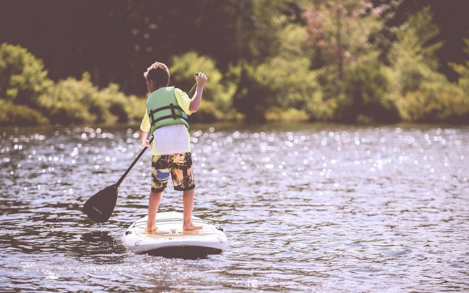 jongen met paddel op het water