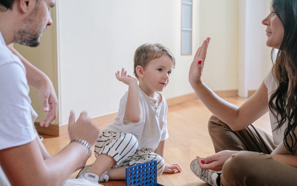 ouders peuter doen spelletje op de grond