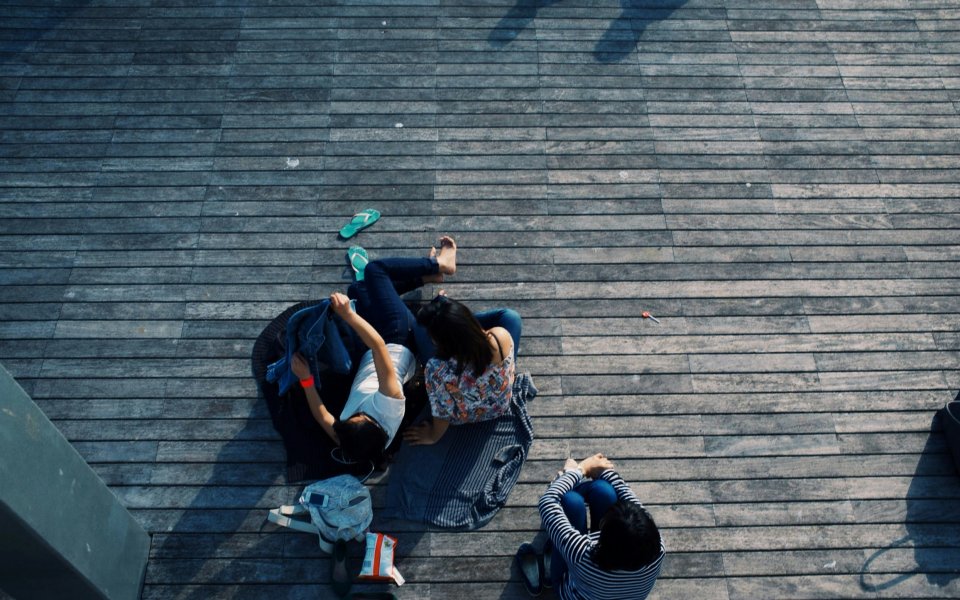 Drie jongeren zitten op een terras