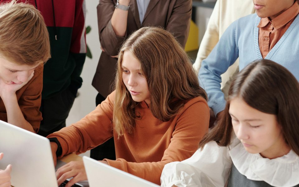 jongeren aan laptop, deel jongeren kijkt toe