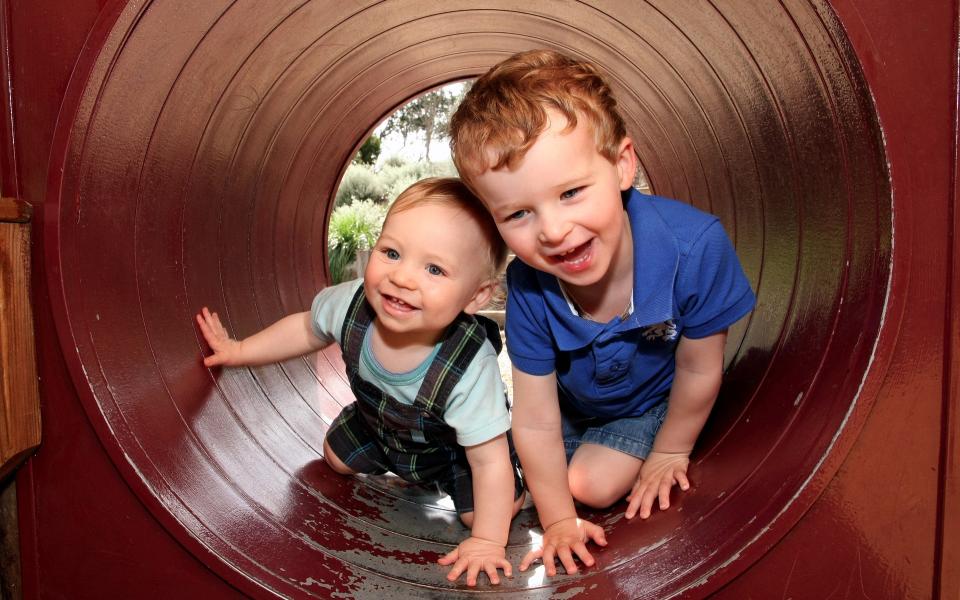 Twee broers spelen in een buis