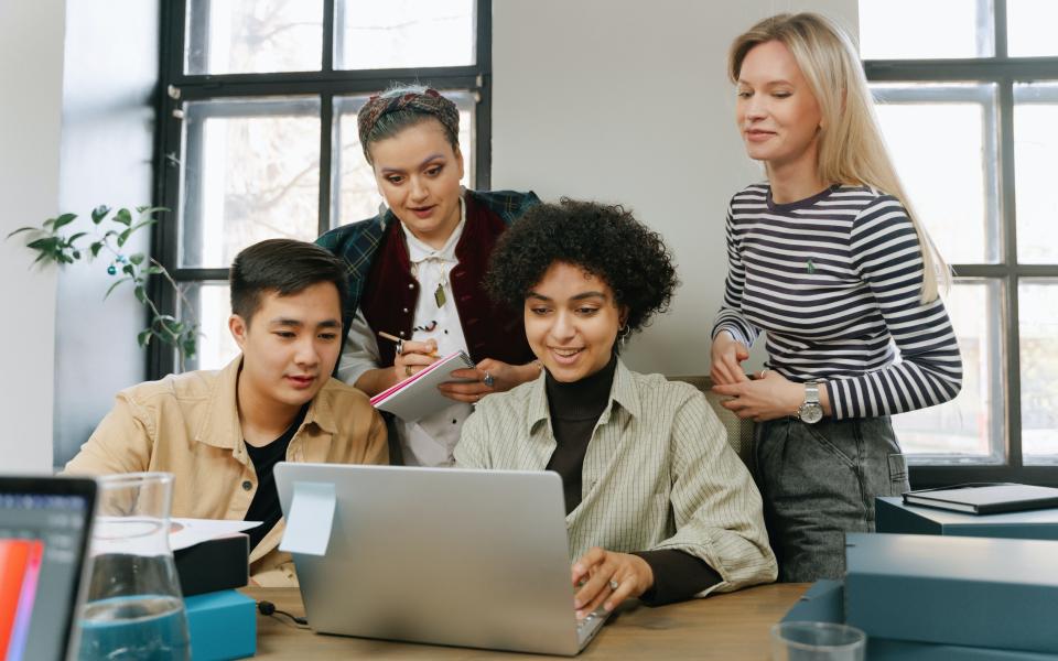 Vier collega's aan een laptop