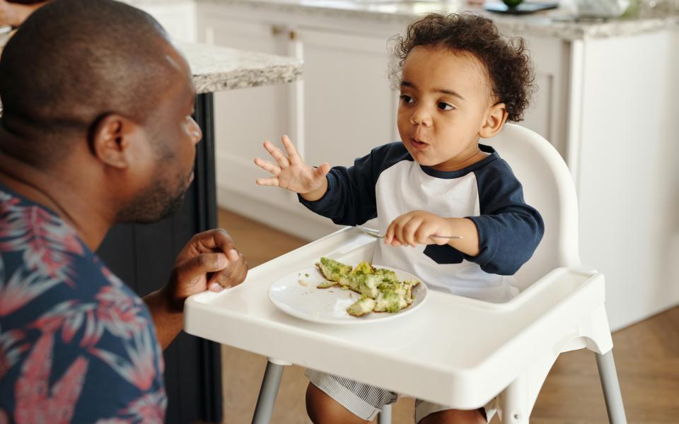 Een vader geeft een kind te eten