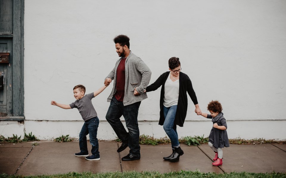 Familie wandelt hand-in-hand over straat, diversiteit, gezin, samenleving