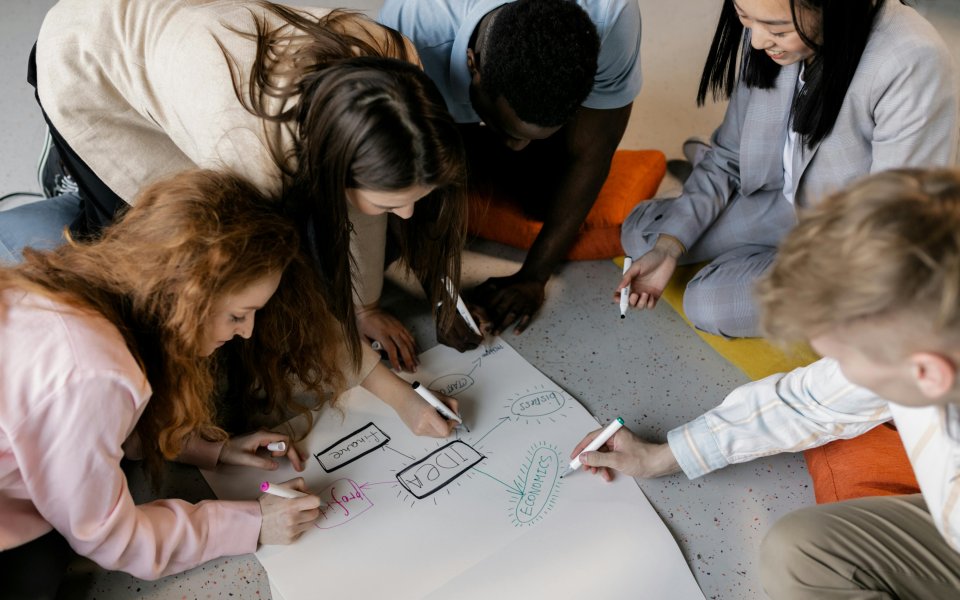 groep jongeren schrijft op een flap op de grond