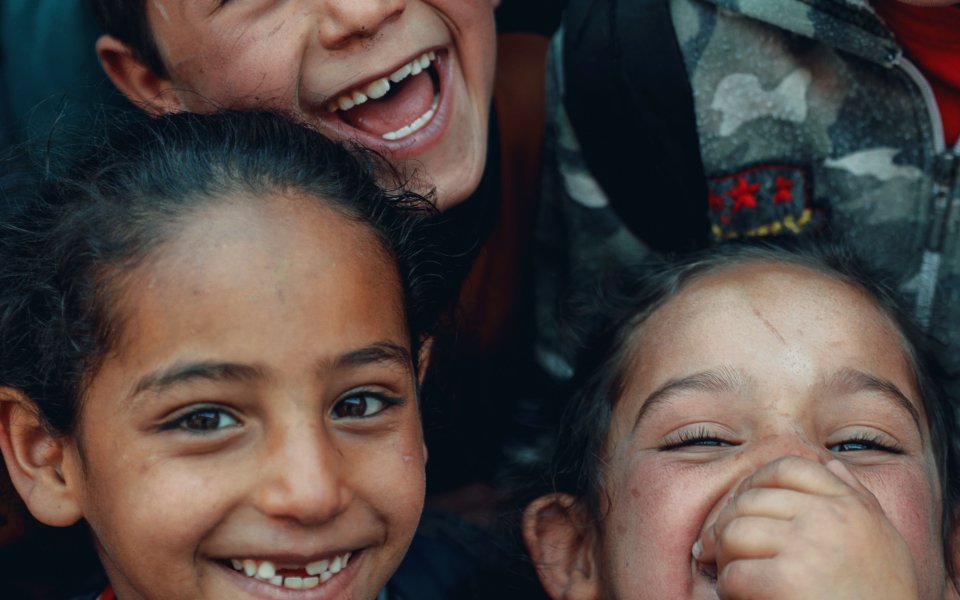 groep-kinderen-kijkt-lachend-naar-boven-in-camera.