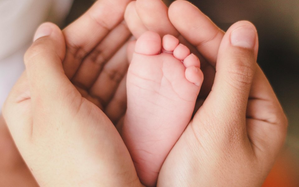 handen-rond-een-babyvoetje