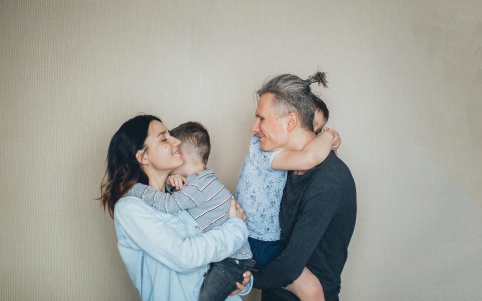 Multiculturele familie dat hun kinderen knuffelt