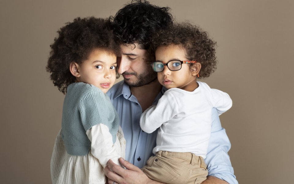 papa met 2 kinderen in zijn armen