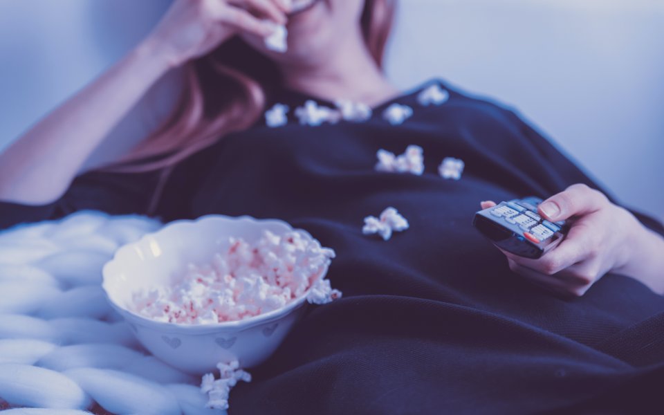 Nieuwsbericht Opgroeien jongere eet uit kommetje popcorn