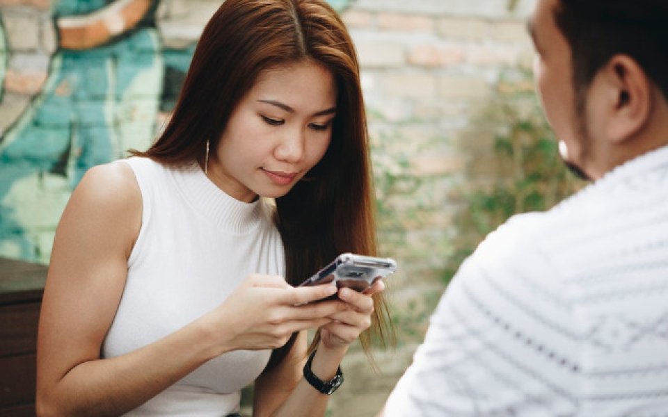 jonge Aziatische vrouw kijkt naar smartphone
