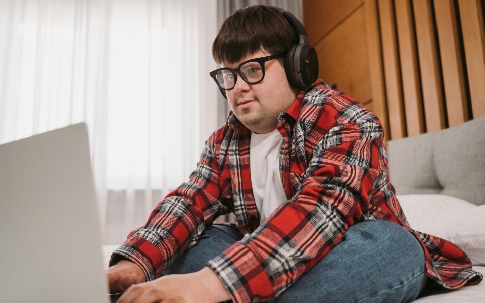 jonge man met syndroom van down typt op zijn laptop