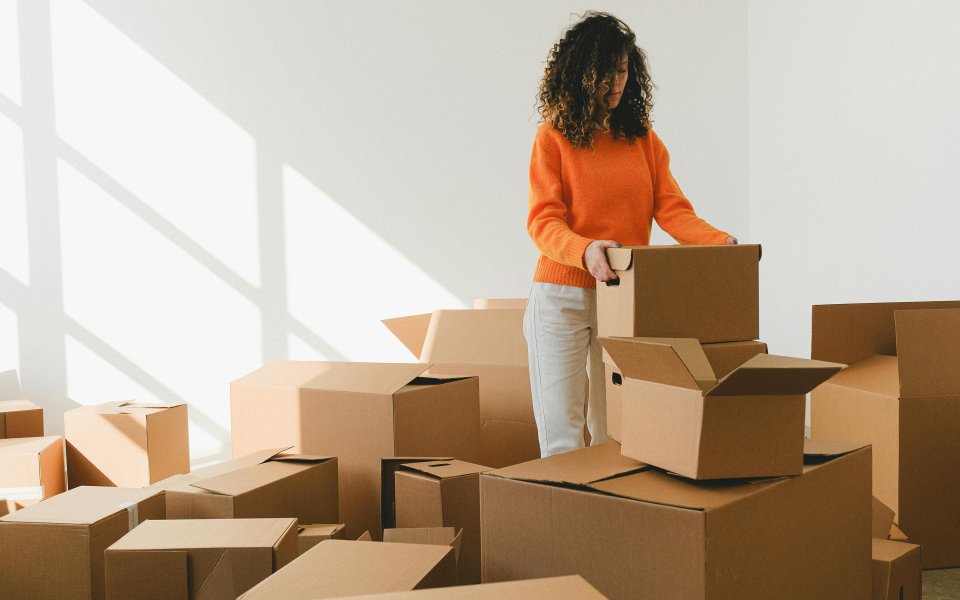 jonge-vrouw-tussen-de-kartonnen-dozen