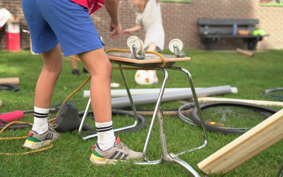jongensbenen-in-short-buiten-aan-het-spelen-met-allerlei-materiaal