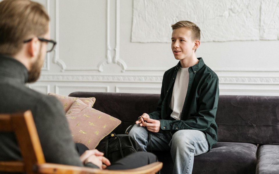 jongere-in-zetel--pratend-met-volwassene.