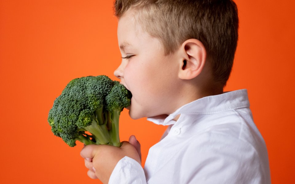 jongetje-bijt-in-een-broccoli.