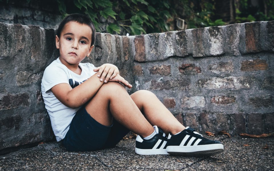 jongetje zit triest op de grond