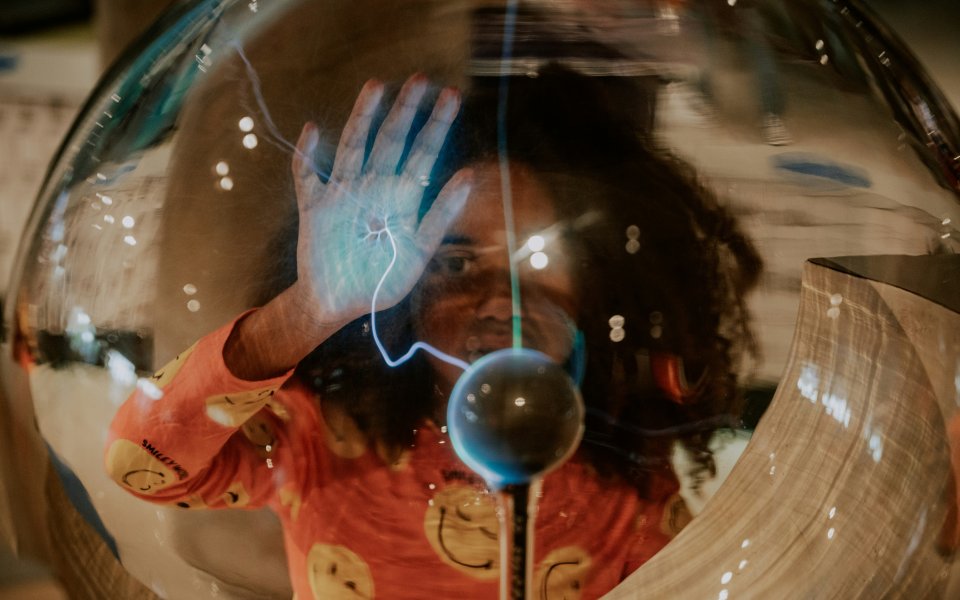 Kind experimenteert met glazen bol en elektriciteit