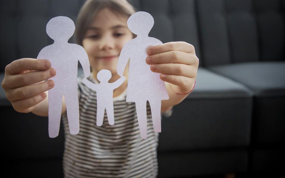 Kind houdt een gezin vast dat uitgesneden is uit papier