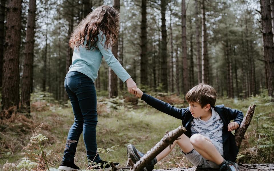 meisje reikt helpende hand aan jongen