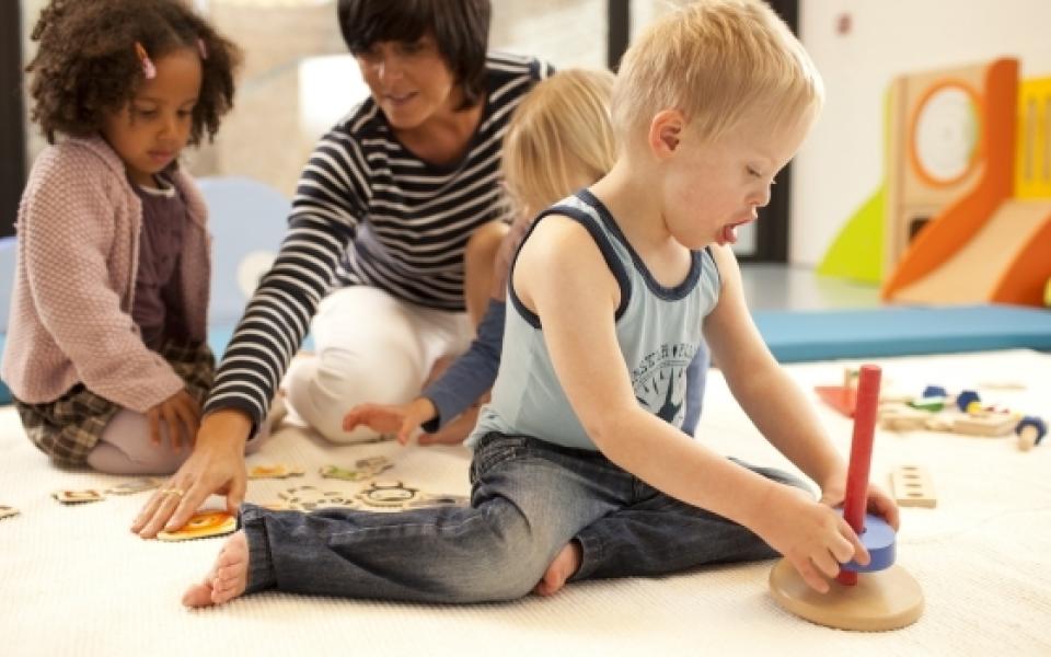 Kind met syndroom van down speelt in de kinderopvang