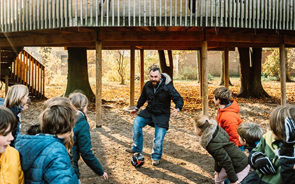 Mike speelt voetbal met een groep kinderen 