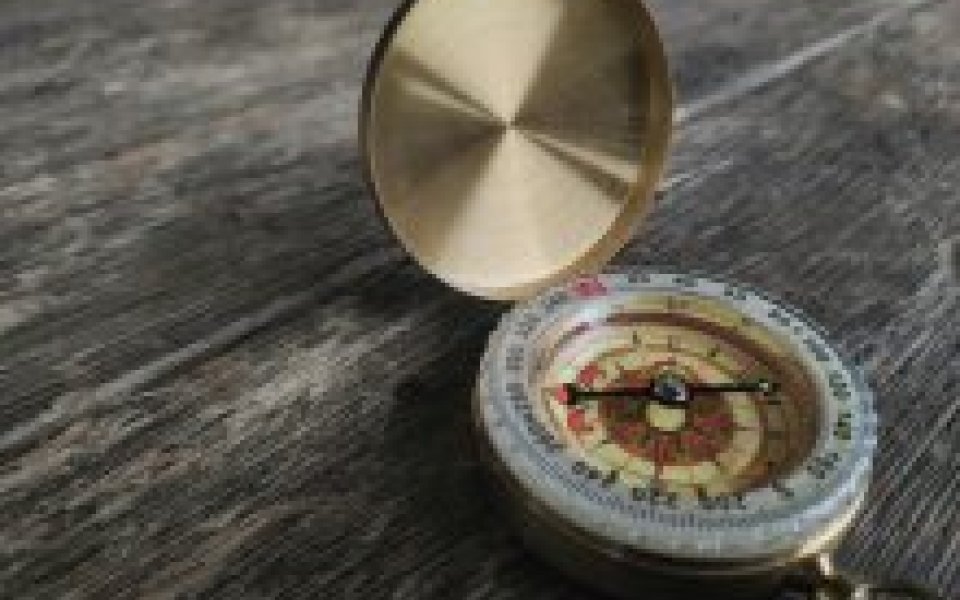 Kompas van een schip op een houten vloer