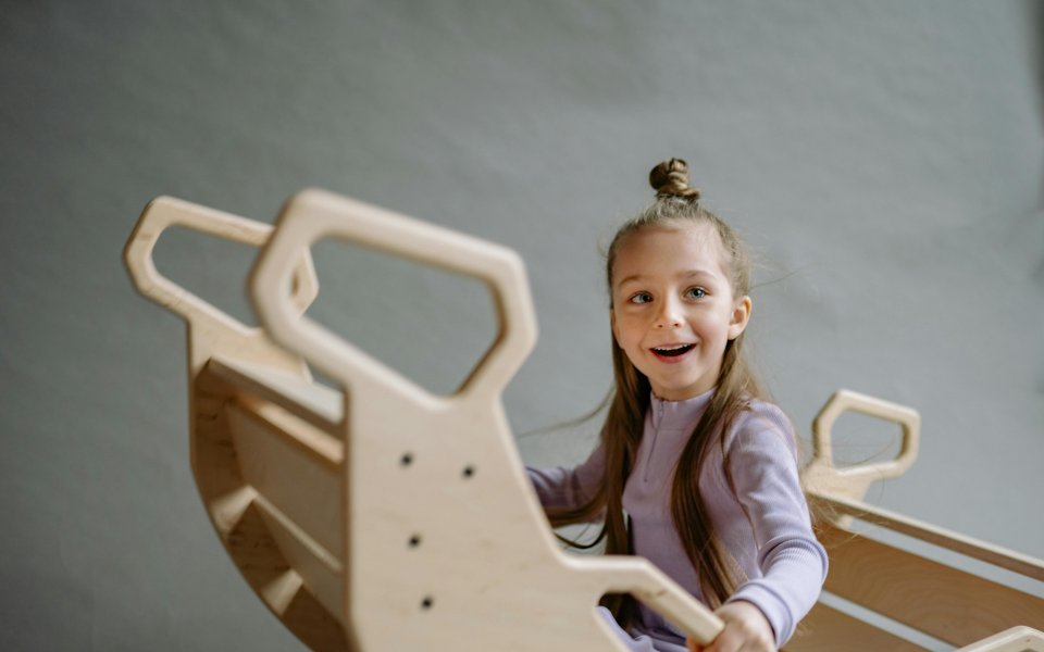 lachend-meisje-in-een-schommel-speeltoestel