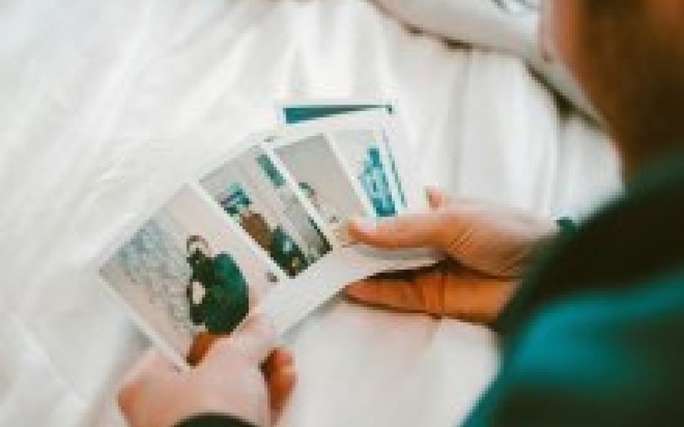 man houdt afgedrukte polaroid foto's in zijn handen