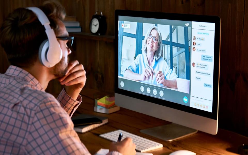 Man luistert naar live webinar met hoofdtelefoon op computer