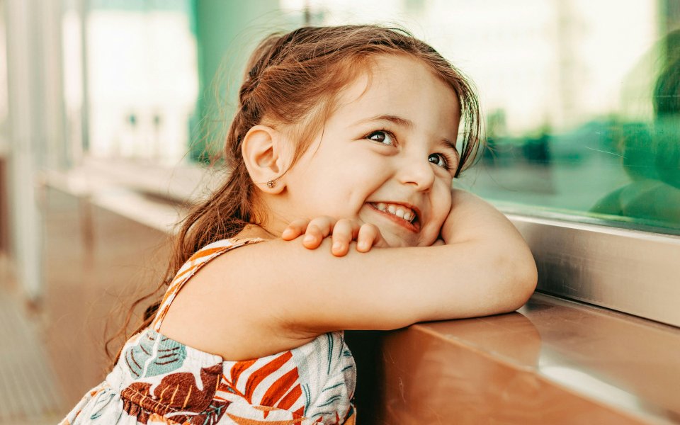 meisje--leunend-op-de-vensterbank--breed-lachend