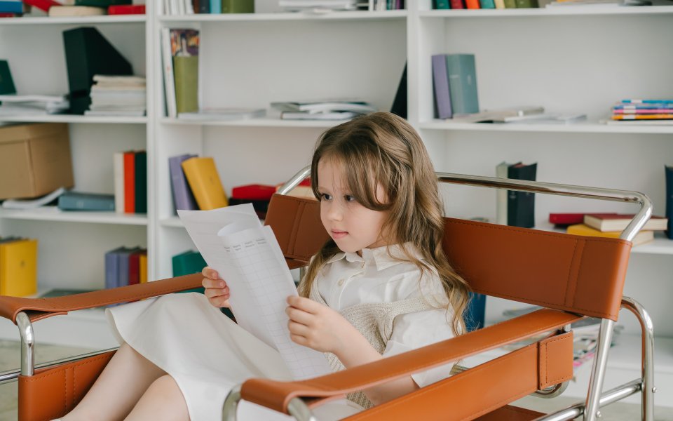meisje-in-stoel-leest-allerlei-papieren