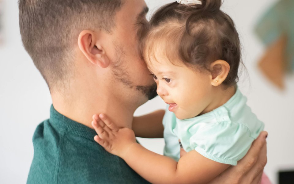 meisje met syndroom van down in armen van adoptievader 