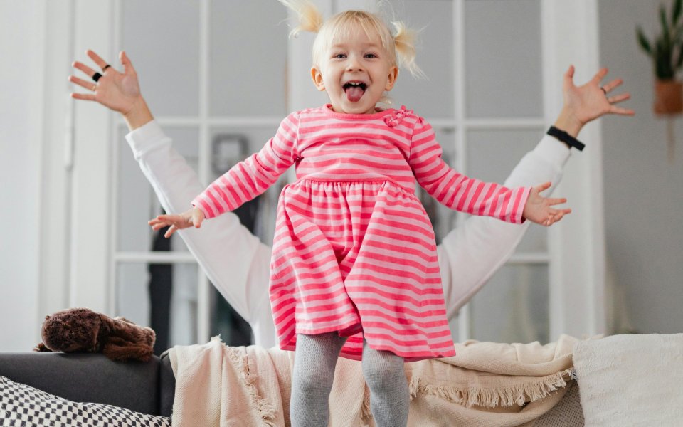 meisje springt lachend van de zetel